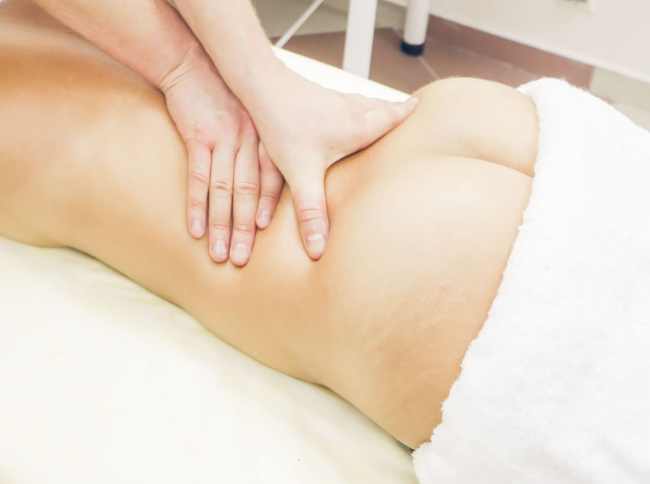 На фото масажист медичного центру Лікар Здоров'я робить антицеюлітний масаж, на сідницях помітно целюліт.