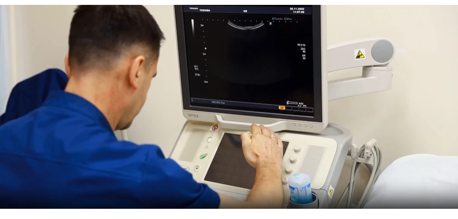 УЗД гінекологічне проводить лікар зазвичай за таким УЗД апаратом. Він прикриває монітор рукою, щоб побачити деталі.